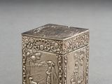 an old silver box sitting on top of a table next to a black background