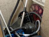 a blue vacuum and a blue bucket in the corner of a bathroom