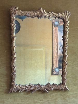 un miroir accroché au mur dans lequel on voit le reflet d'une femme