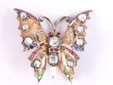 une broche en forme de papillon en or, ornée de pierres multicolores