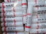 many tubes of glue in a box on a table