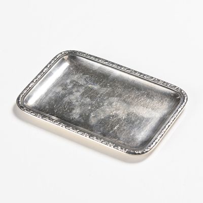 rectangular silver plate with beaded edge on white surface