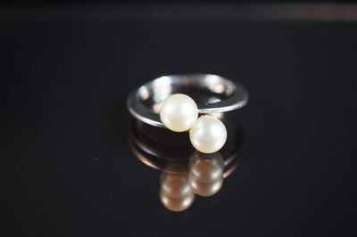 deux perles blanches reposent sur une surface noire