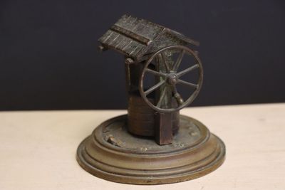 une statue représentant une roue posée sur une table en bois