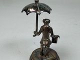 a statue of a man holding an umbrella on a table