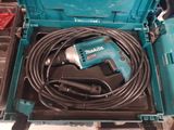 une perceuse filaire dans une boîte à outils, avec son cordon d'alimentation