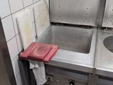 a sink in a kitchen with a red towel on the counter