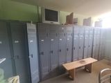 de nombreux casiers dans une pièce équipée d'un banc et d'un téléviseur