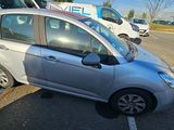 a small silver car parked in a parking lot