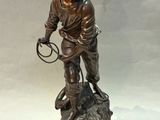 bronze statue of a boy with a dog on a rock
