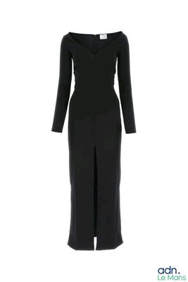 La robe est noire, à manches longues et avec un col en V.