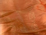 a close up of an orange scarf on a bed