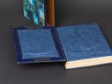 an open book with a blue cover sitting on a table