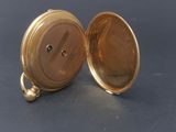 an image of a gold pocket watch sitting on top of a table