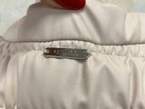 a woman ' s hand holding a white jacket with a red nail