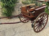 a horse drawn carriage parked in front of a brick wall