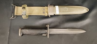 un couteau et un porte-couteau posés sur un tissu noir