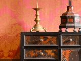 une commode sur laquelle est posée une lampe, dans une pièce