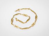 un ensemble composé d'un collier et d'un bracelet plaqués or, sur fond blanc