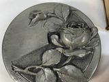 a silver plate with a rose on it next to a box
