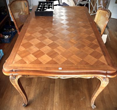 a large wooden table with chairs around it in a living room