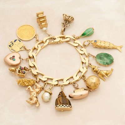 a gold bracelet with many different charms on it