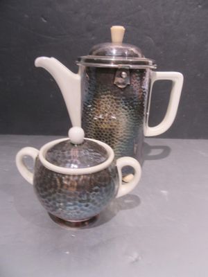 une théière et une tasse posées sur une table