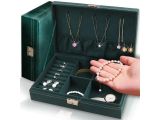 a woman ' s hand holding a jewelry box with many necklaces and bracelets