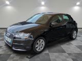 la voiture noire est garée sur un sol en damier dans le garage