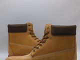 un gros plan sur une paire de bottes jaunes sur fond blanc