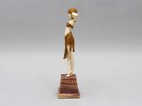 a statue of a woman holding a bowl on top of a wooden base