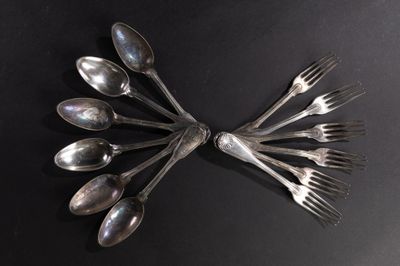 plusieurs cuillères et fourchettes disposées en cercle sur une surface noire