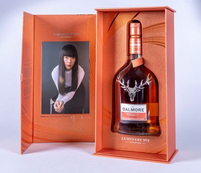 une image représentant une bouteille de whisky dans un coffret orné d'une photo de femme