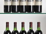 several bottles of wine are lined up on a glass shelf