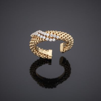a gold ring with diamonds on a black surface