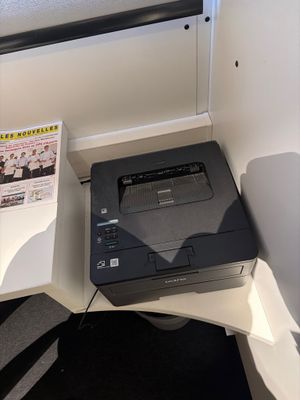 une imprimante posée sur un bureau dans un coin de la pièce