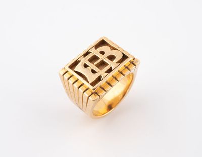 un gros plan d'une bague en or sur laquelle figure la lettre b