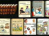 Plusieurs livres sont alignés sur une table devant un fond noir.