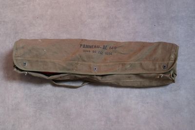 un sac posé par terre, sur lequel est collée une étiquette