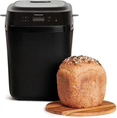 a loaf of bread sitting next to a bread dispenser on a cutting board