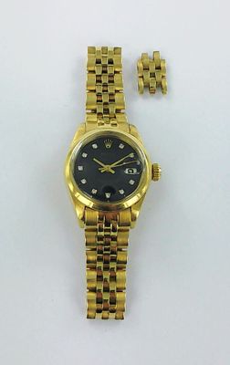 un gros plan d'une montre et d'un bracelet posés sur une surface blanche
