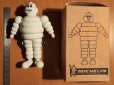 une figurine représentant un homme debout à côté d'un carton