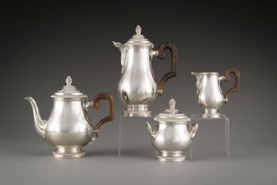four pieces of silver tea and coffee set on clear acrylic bases