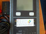 appareil électronique posé sur une table en bois, à côté d'un chargeur