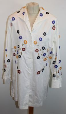 une image représentant une chemise blanche ornée de fleurs colorées