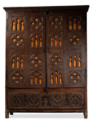une vieille armoire en bois avec des sculptures et des gravures sur les portes