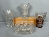 trois vases en verre, un bol et un bol posé sur un socle en bois