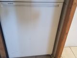 a white dishwasher sitting in the corner of a kitchen