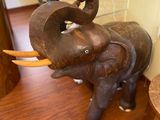 a statue of an elephant that is standing on a wooden floor