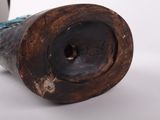 a brown vase with a blue handle on a white surface
